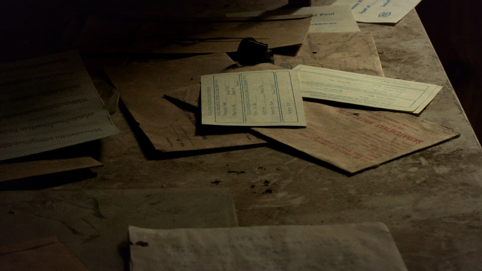 Paper records spread across a worn wooden table