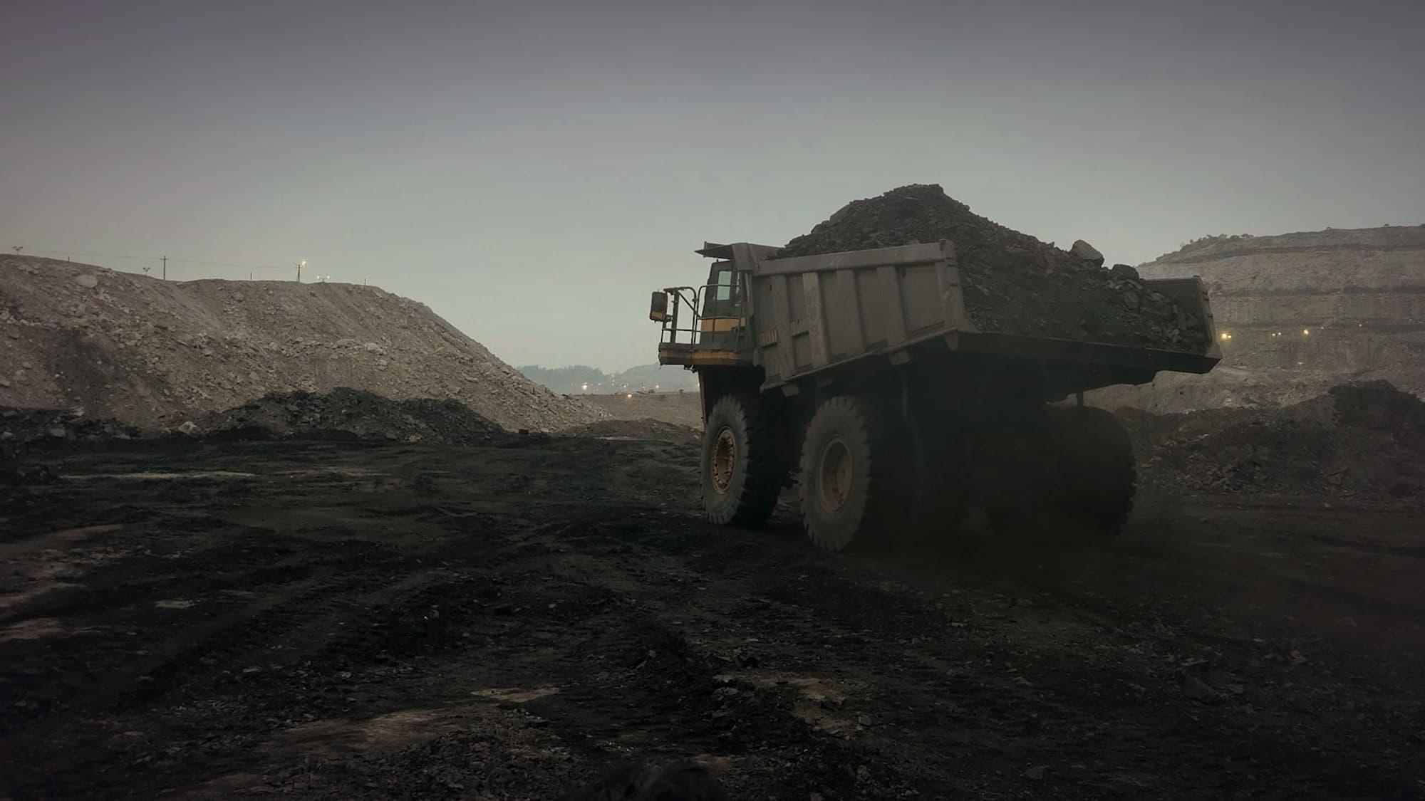 A haul truck carrying coal through an open-pit mine